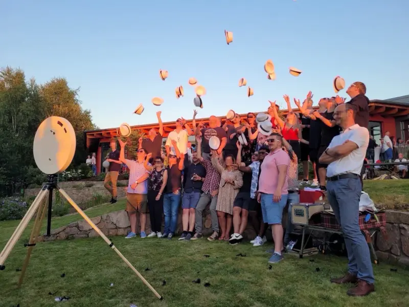 Fotobox mieten – Gruppe wirft Hüte in die Luft bei Gartenparty